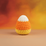 Crocheted candy corn toy on a warm-toned background