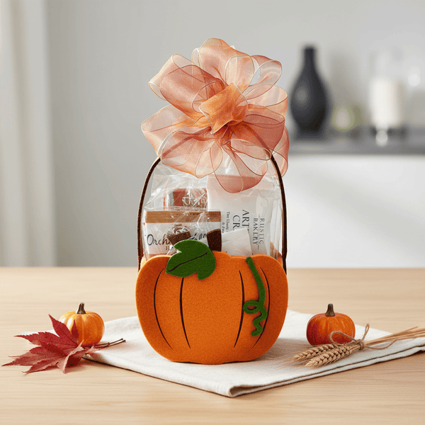 Pumpkin-shaped gift bag with a floral bow on a table with pumpkins and leaves.