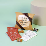 Coffee gift set with a brown box, coffee packets, and a card on a light green background