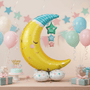 Jumbo 55 Moon & Stars Balloon centerpiece at a pastel-themed baby shower setup, featuring a sleepy moon with hanging stars and coordinating pastel decorations.