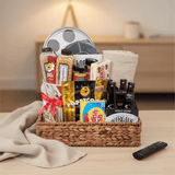 Gift basket with snacks, drinks, and movie theater items on a table.