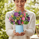 Person presents a Spring Floral Pop Up Card, featuring a vibrant bouquet in a blue pot, embodying the essence of everlasting Spring.